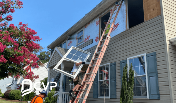 Men climbing the ladder by holding replacement windows